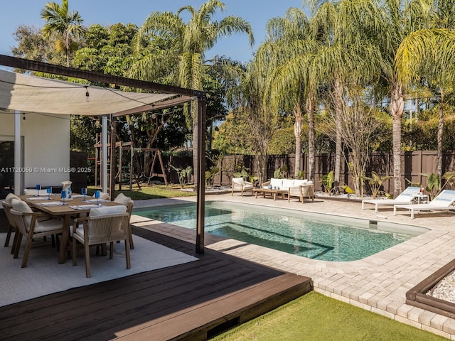 view of pool with outdoor dining space, an outdoor living space, a fenced backyard, a playground, and a fenced in pool