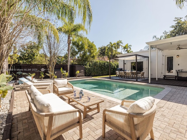 view of swimming pool featuring a fenced in pool, a ceiling fan, a fenced backyard, outdoor lounge area, and a patio area