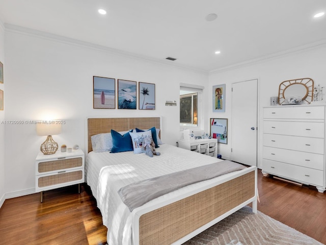 bedroom featuring recessed lighting, wood finished floors, baseboards, and ornamental molding