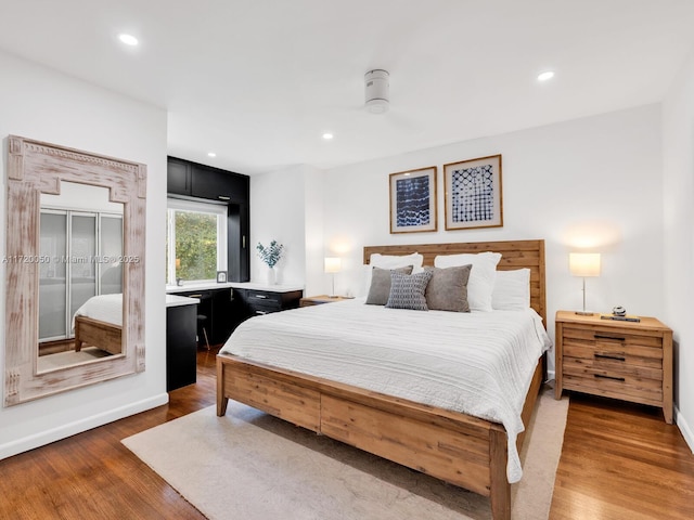 bedroom with recessed lighting, baseboards, and wood finished floors