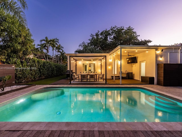 view of swimming pool featuring a deck, a fenced in pool, a ceiling fan, and fence