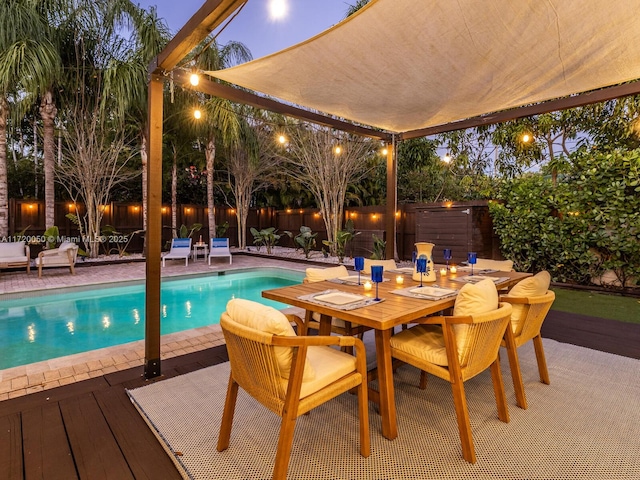 view of pool with outdoor dining space, a fenced in pool, a patio, and a fenced backyard