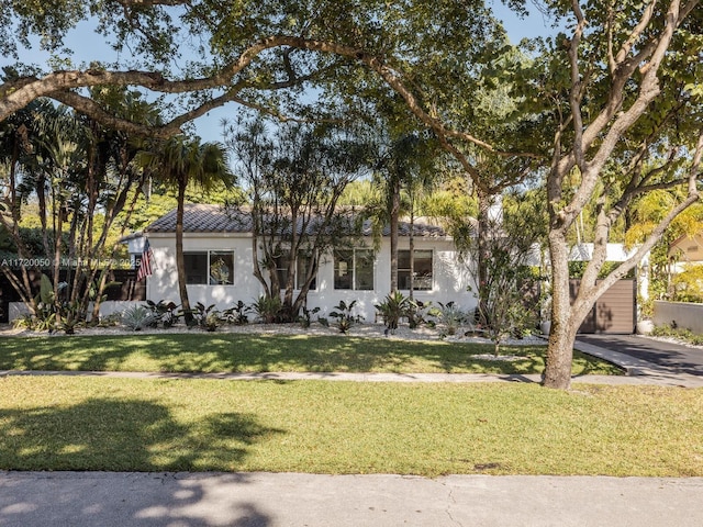 mediterranean / spanish home with a front lawn, driveway, and stucco siding