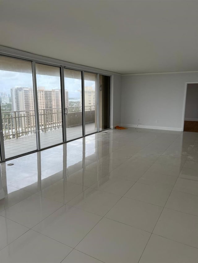 tiled spare room featuring expansive windows