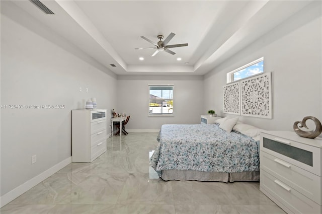 bedroom with a raised ceiling and ceiling fan