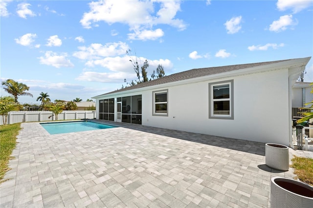 view of swimming pool with a sunroom and a patio