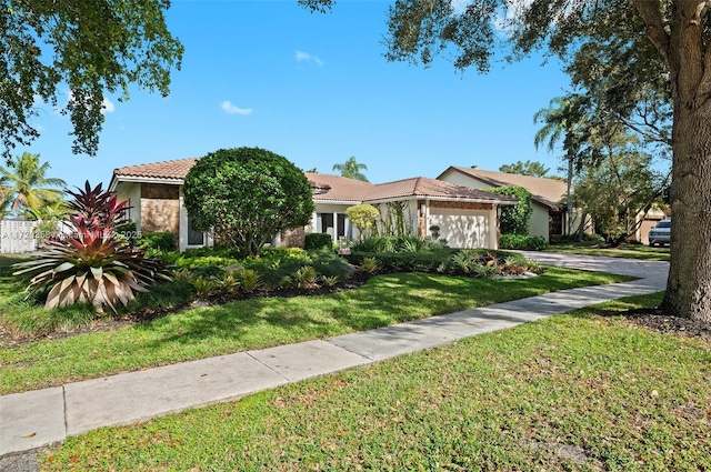 mediterranean / spanish-style house featuring a garage and a front lawn