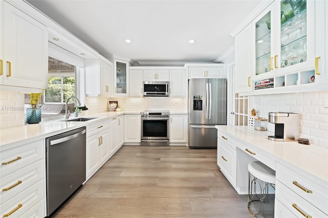 kitchen featuring stainless steel appliances, white cabinetry, tasteful backsplash, and sink