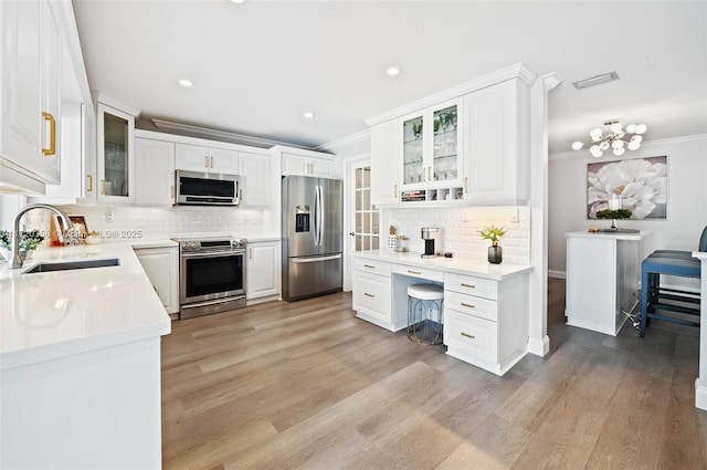 kitchen featuring appliances with stainless steel finishes, white cabinetry, and sink