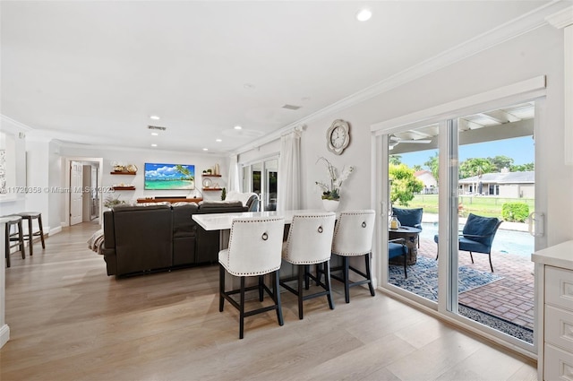 dining area with light hardwood / wood-style flooring and ornamental molding