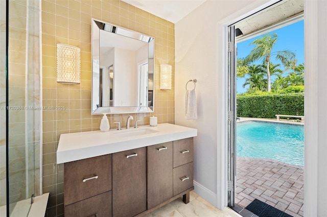 bathroom featuring vanity, a shower with door, and tile walls