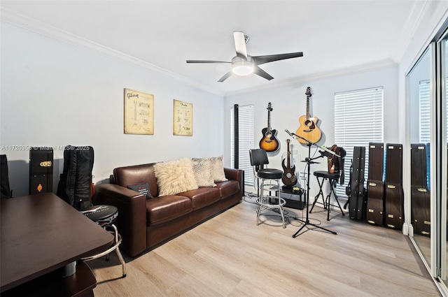 living room with light wood-type flooring, ceiling fan, and crown molding