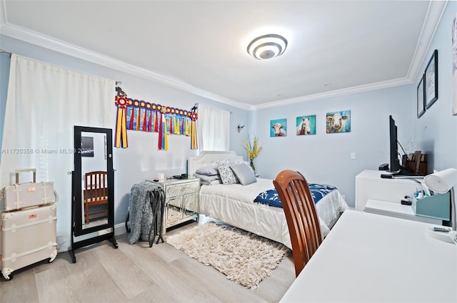 bedroom with light wood-type flooring and crown molding