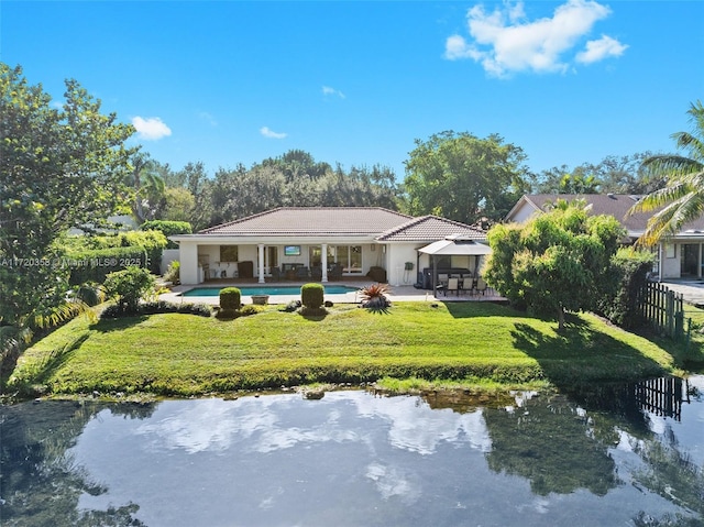 back of house featuring a gazebo, a patio area, a water view, and a yard