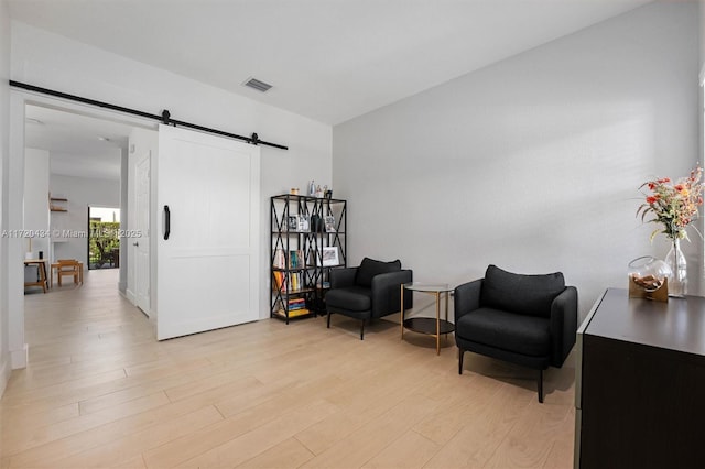 sitting room featuring a barn door and light wood-type flooring