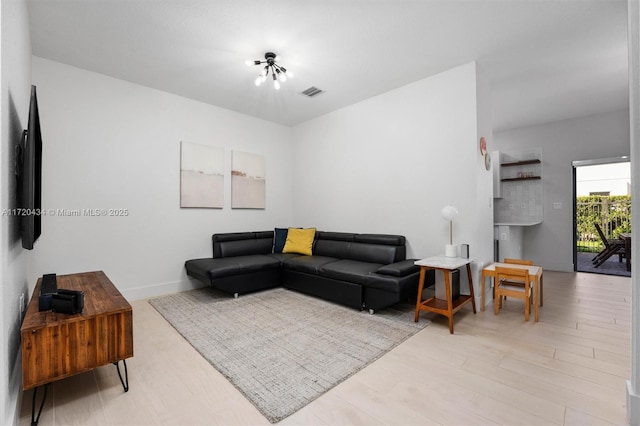 living room with light wood-type flooring and a notable chandelier