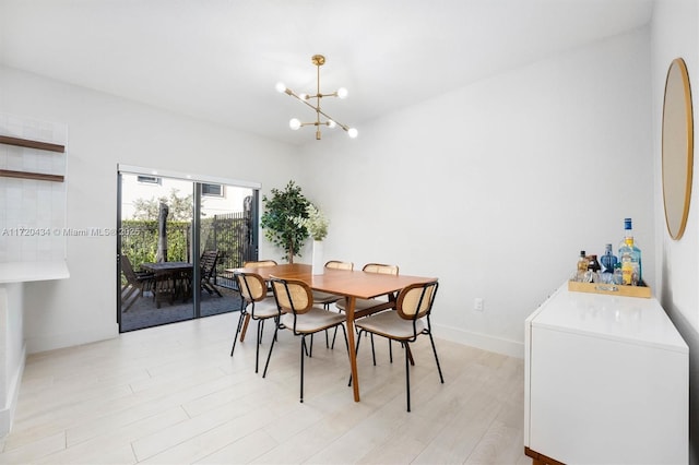 dining space with light hardwood / wood-style floors and an inviting chandelier