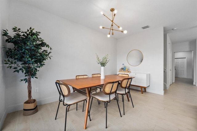 dining room featuring light wood-type flooring and a notable chandelier