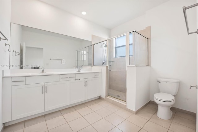 bathroom with tile patterned flooring, a shower with door, vanity, and toilet