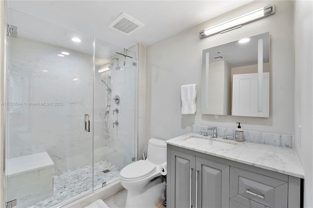 bathroom with an enclosed shower, vanity, and toilet