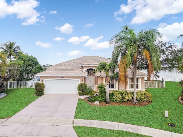 view of front of home featuring a garage, a water view, and a front lawn