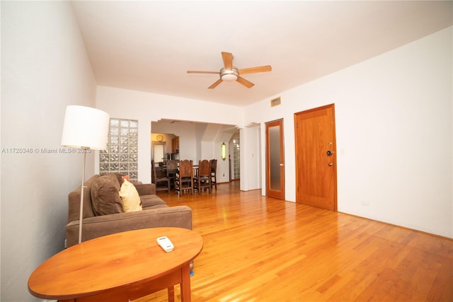 living room featuring ornate columns, ceiling fan, and hardwood / wood-style flooring