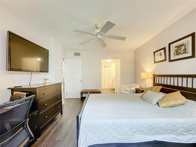 bedroom featuring wood-type flooring, a textured ceiling, and ceiling fan