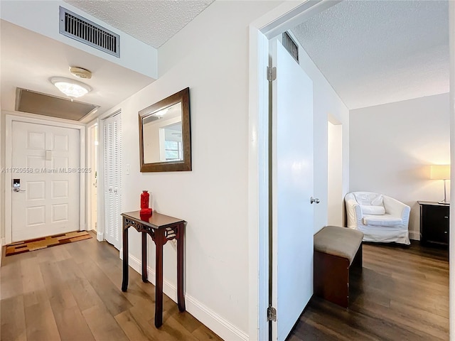 corridor featuring hardwood / wood-style flooring and a textured ceiling