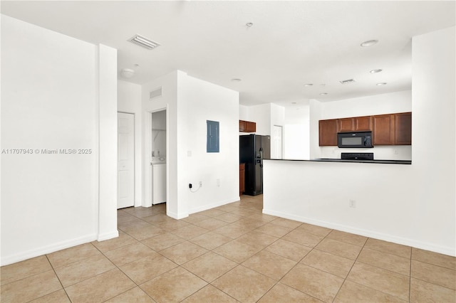 kitchen with light tile patterned flooring, electric panel, and black appliances