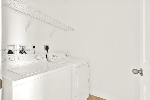 laundry area with separate washer and dryer and light tile patterned floors