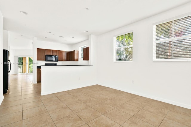 kitchen with light tile patterned floors and black appliances