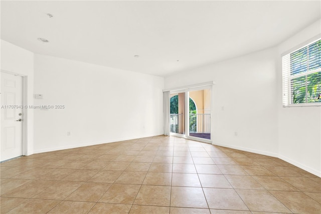 empty room featuring a wealth of natural light and light tile patterned floors