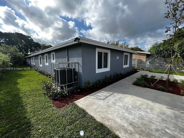 view of property exterior with a yard, central AC unit, and a patio area