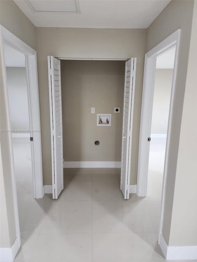 washroom with hookup for an electric dryer, hookup for a washing machine, and light tile patterned floors