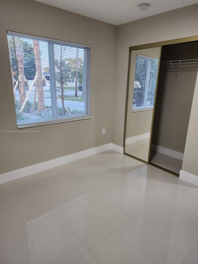 unfurnished bedroom with tile patterned flooring and a closet