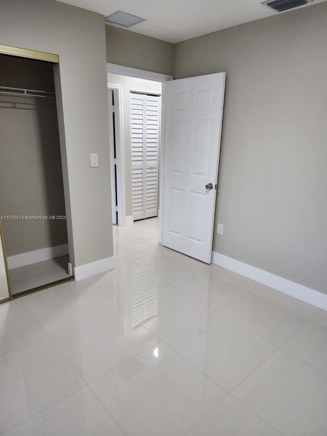 unfurnished bedroom with a closet and light tile patterned flooring