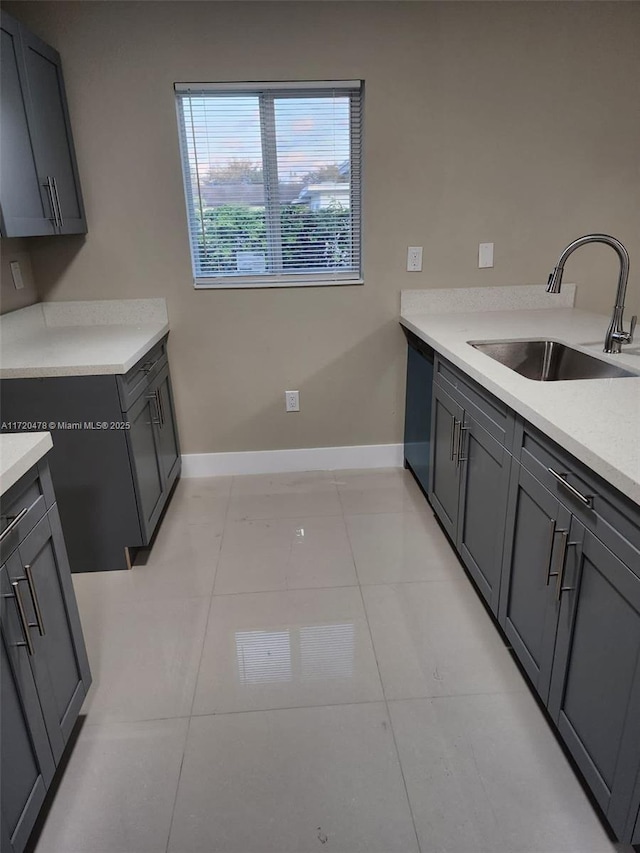 kitchen featuring gray cabinetry, sink, light tile patterned floors, and black dishwasher