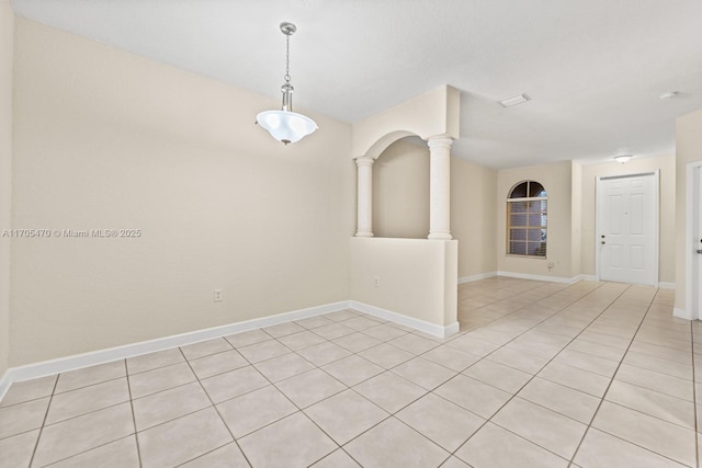 spare room featuring ornate columns and light tile patterned flooring