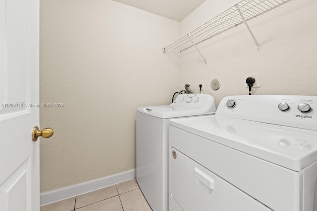 laundry room with washing machine and dryer and light tile patterned floors