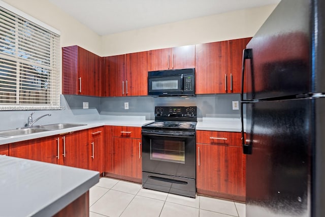 kitchen with light tile patterned floors, sink, and black appliances