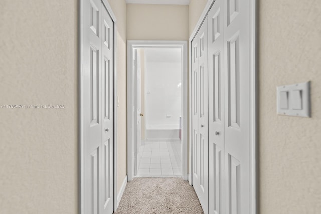 hallway featuring light colored carpet