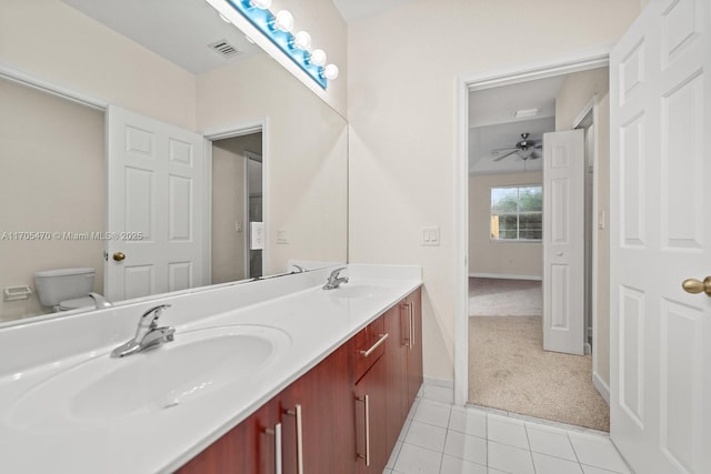 bathroom with tile patterned floors, vanity, ceiling fan, and toilet