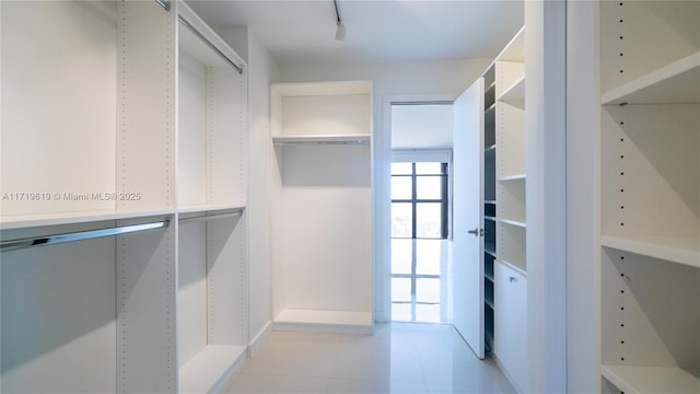 spacious closet featuring light tile patterned flooring