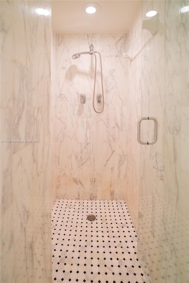 bathroom featuring a marble finish shower