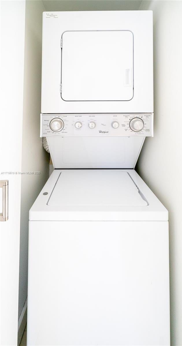 clothes washing area with stacked washer and dryer and laundry area