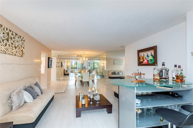 living room featuring a textured ceiling and an inviting chandelier