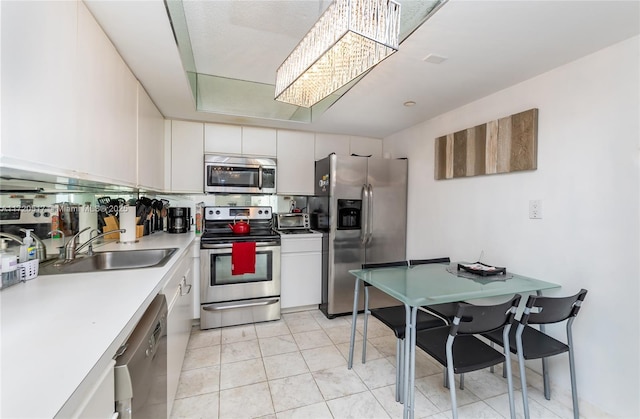 kitchen featuring white cabinets, sink, light tile patterned floors, and stainless steel appliances