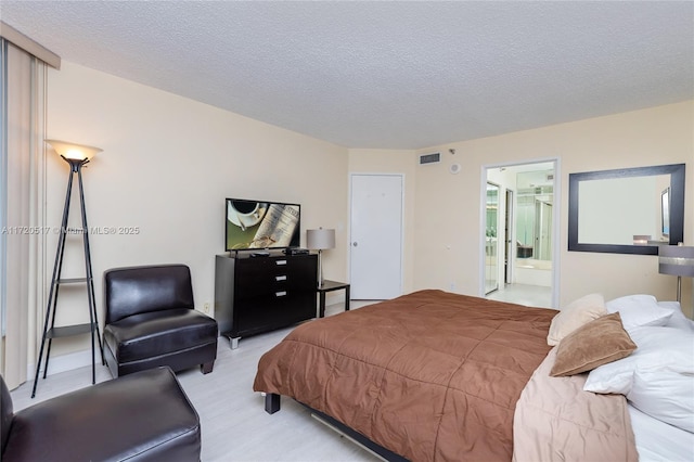 bedroom featuring ensuite bathroom and a textured ceiling