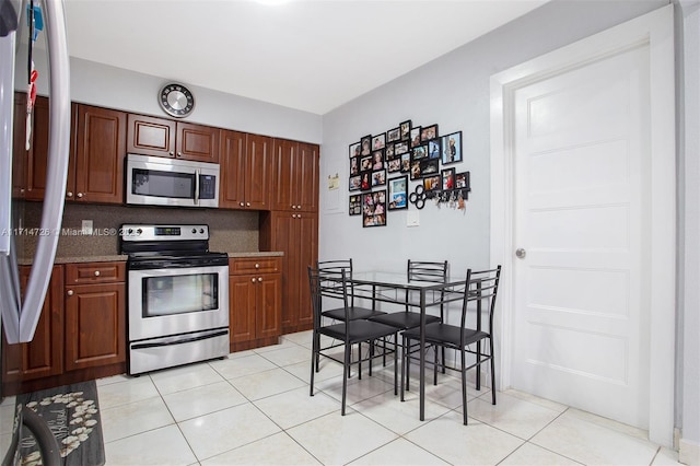 kitchen with appliances with stainless steel finishes, backsplash, and light tile patterned floors