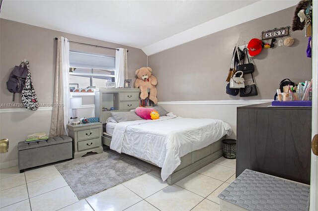 tiled bedroom featuring lofted ceiling